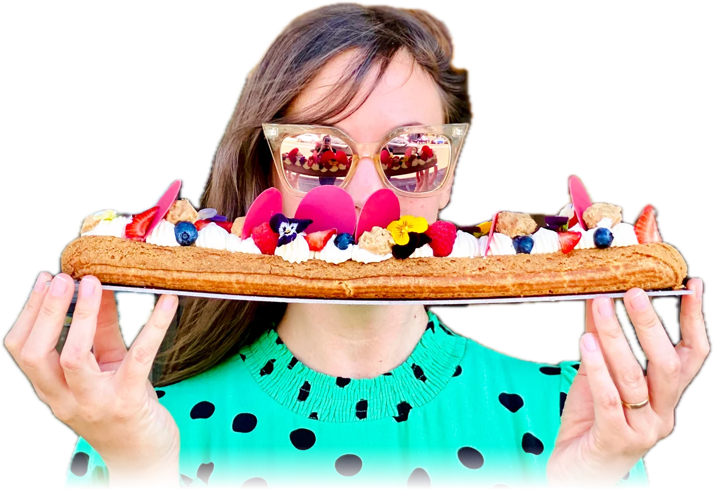 Madame holding a decorated 40 centimetre Eclairzilla in front of the patisserie