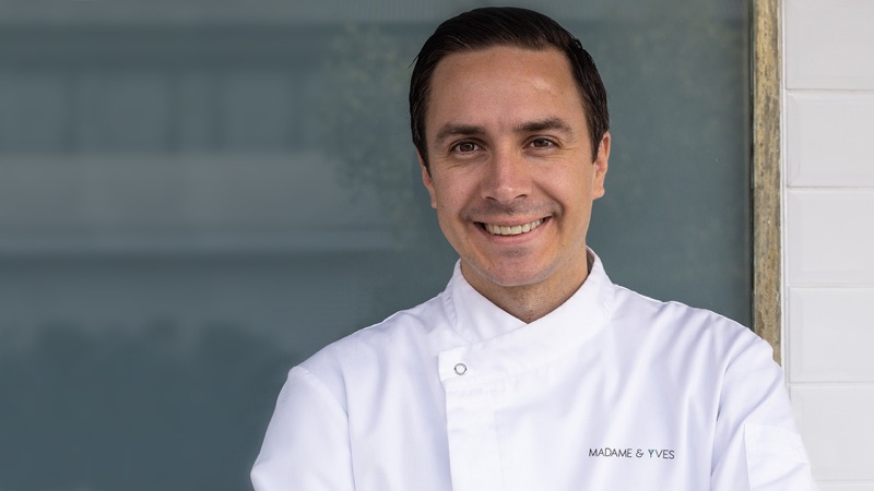 Chef Yves Scherrer smiling, in his Madame & Yves chef whites