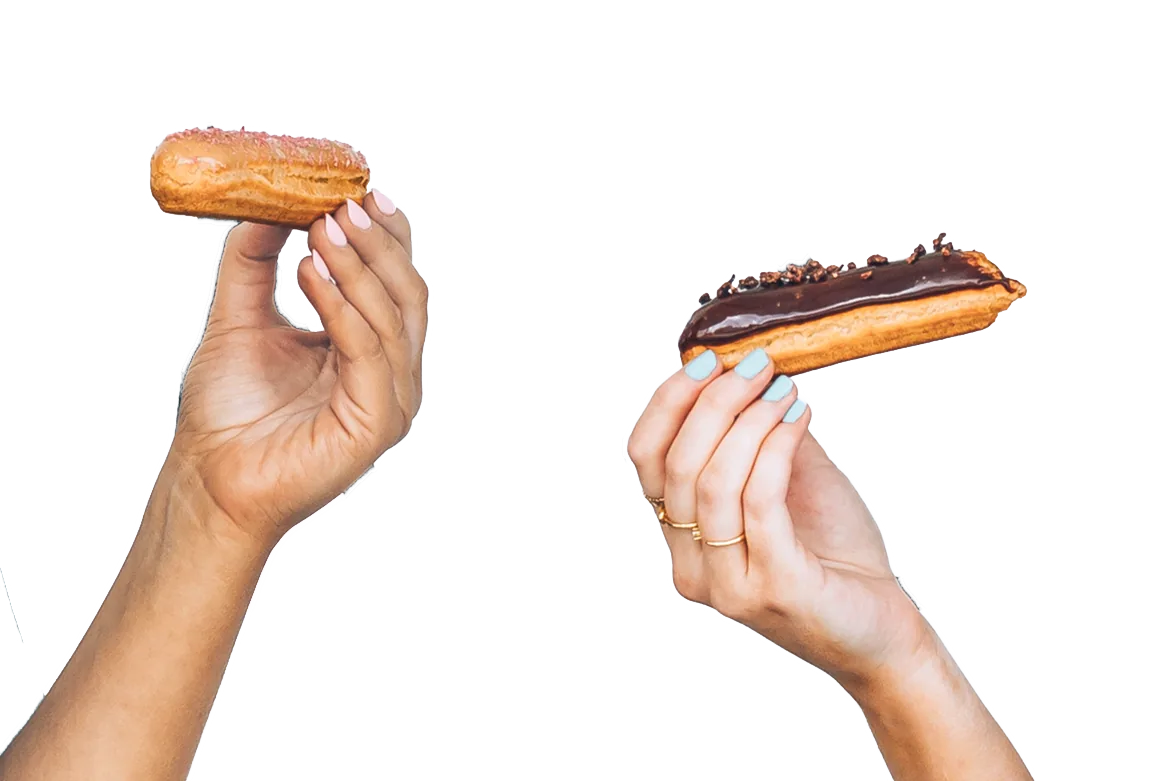 Two hands holding up Madame & Yves éclairs
